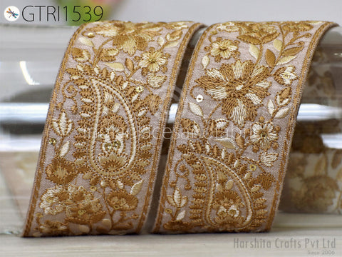 two ornate gold and white embroidered ribbons with intricate floral designs.