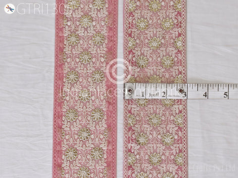 two pieces of fabric with a floral pattern in pink and white colors. A ruler is placed between the two pieces of fabric, indicating their size.
