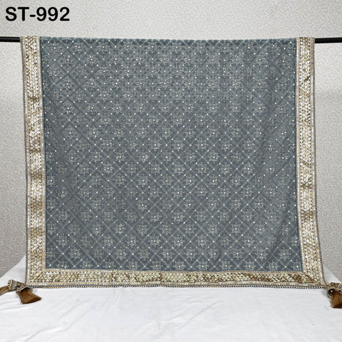a grey and gold patterned fabric with a decorative border, hanging on a wall.