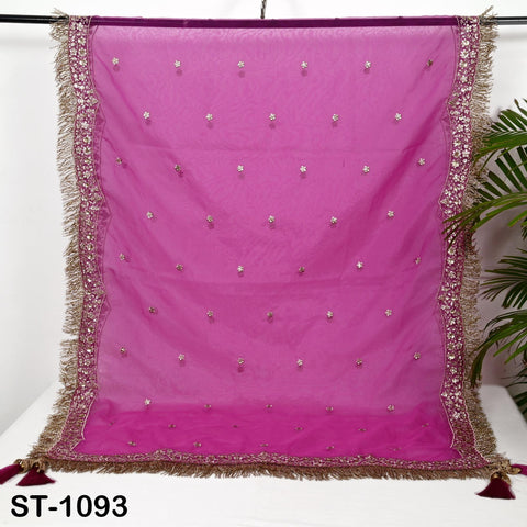a pink fabric with gold trim and small white dots, hanging on a white surface.