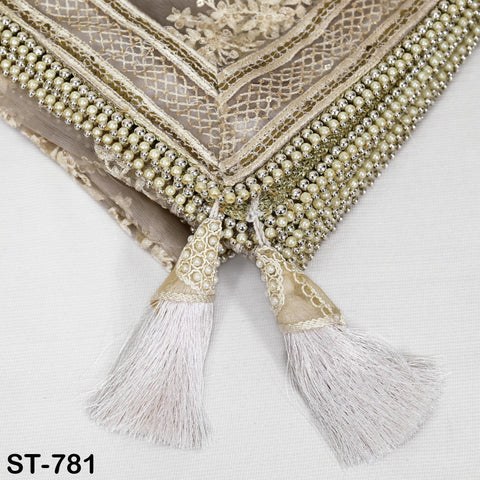 a close-up view of a decorative fabric with a beaded and lace trim design. The fabric has a beaded tassel and lace trim, giving it an elegant and intricate appearance.