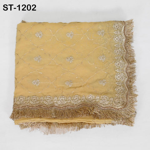 a yellow fabric with intricate gold embroidery and fringe details, displayed against a white background.