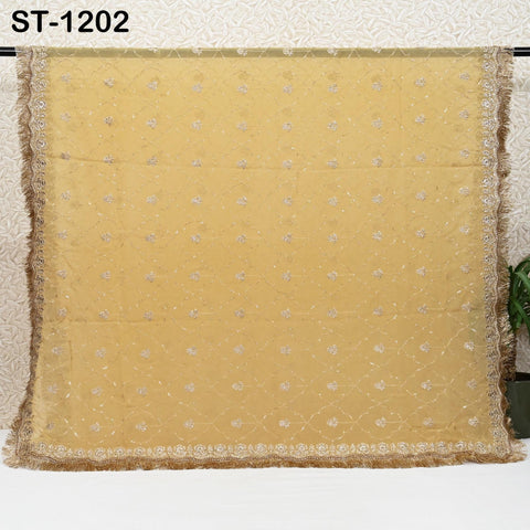 a large, gold-colored fabric with a floral pattern, hanging on a wall.