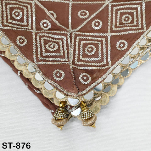 a close-up view of a brown fabric with intricate gold and white embroidered designs, including a diamond pattern and small circles. The fabric appears to be a decorative piece, possibly a handbag or accessory.