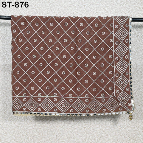 a brown and white patterned fabric hanging on a wall, with a decorative border around the edge.