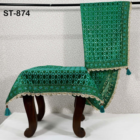 a pair of ornate green and gold table covers with intricate patterns, hanging on a metal rod.