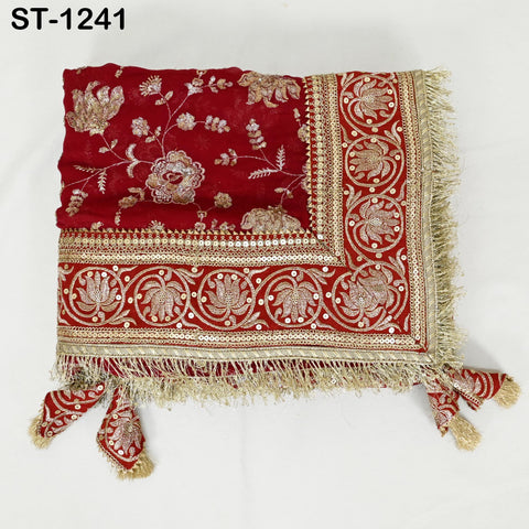 a red and gold embroidered fabric with a decorative border, featuring intricate floral and leaf patterns.