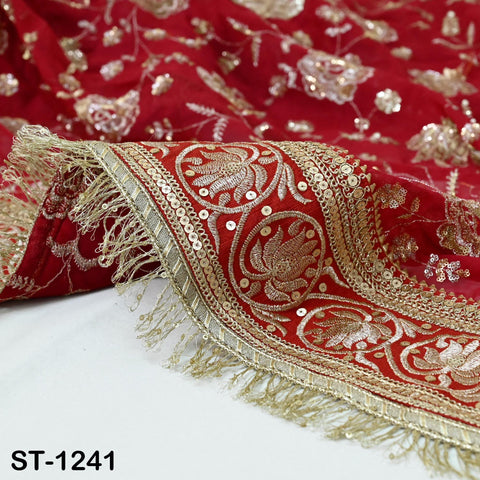 a close-up view of a red and gold embroidered fabric with intricate designs and fringe details.