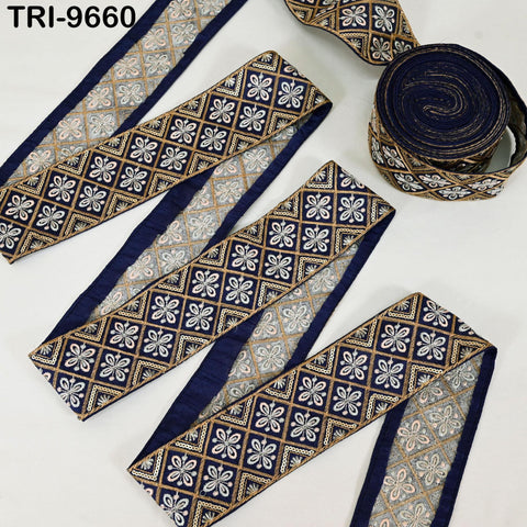 several rolls of decorative fabric with a repeating pattern of blue and gold floral designs. The rolls are arranged on a white background, showcasing the intricate and visually appealing patterns.