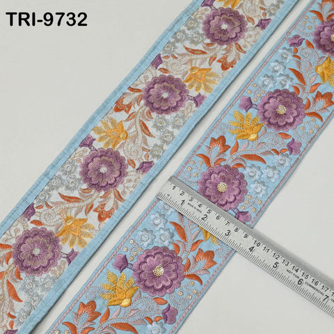 two pieces of fabric with a floral pattern, one with a blue border and the other with a light blue border. A ruler is placed on the right side of the fabric, indicating the size of the fabric.