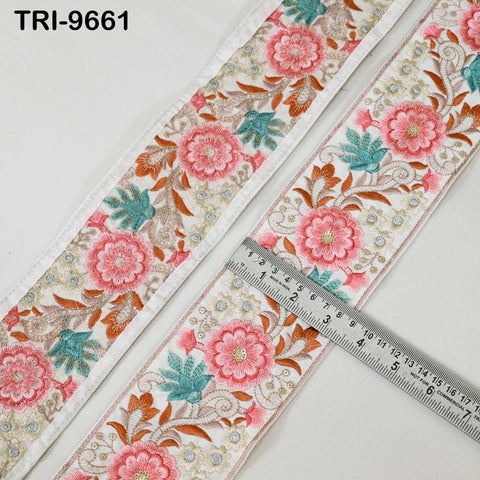 two pieces of fabric with a floral pattern, laid out on a white surface. A ruler is placed between the two pieces of fabric, indicating their size or dimensions.