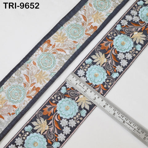 two pieces of fabric with a floral pattern, one with a blue border and the other with a black border. A ruler is placed on the black fabric, indicating the size of the fabric.