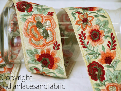 A decorative fabric with a floral pattern in shades of green, red, and orange.