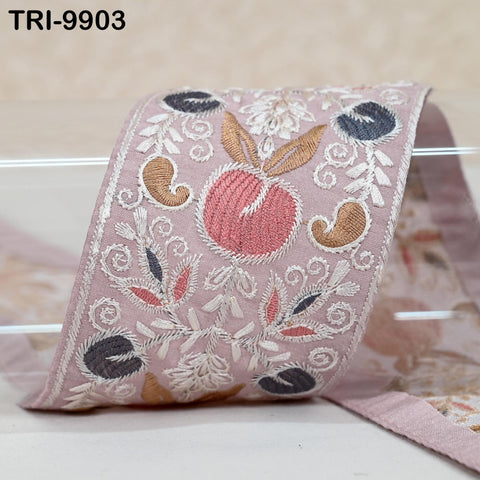 a decorative fabric with a floral pattern and a large embroidered peach design.