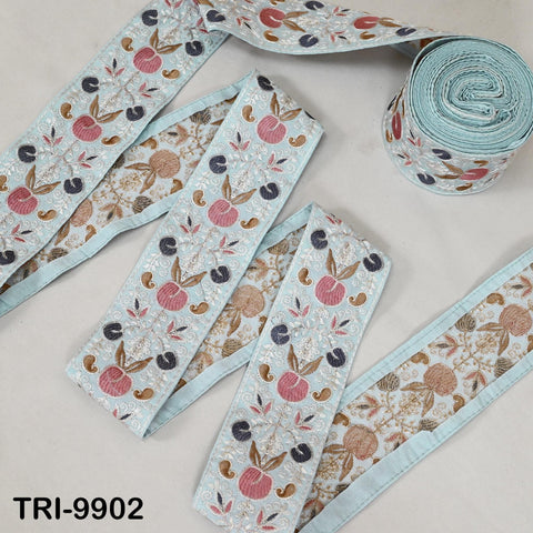 a collection of embroidered fabric pieces with floral patterns in shades of blue, pink, and brown. The pieces are arranged on a white surface, with some of them rolled up and others laid out flat.