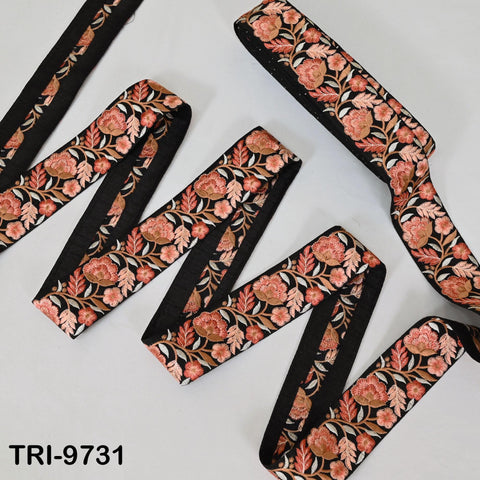 several spools of ribbon with a floral pattern in shades of pink and black.