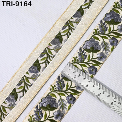 a close-up view of a decorative fabric with a floral pattern, featuring a ruler for scale.