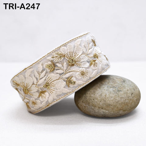 a decorative fabric with a floral pattern, placed on a white surface next to a rock.