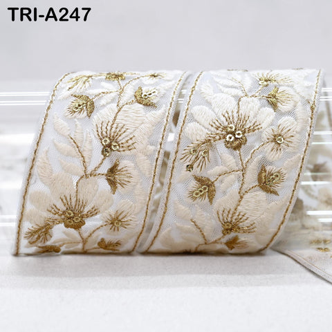 a decorative ribbon with a floral pattern, including white flowers and gold accents.