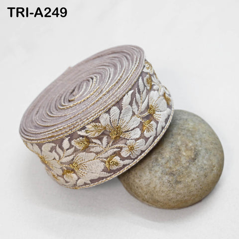 a decorative fabric with a floral pattern, placed on a white surface next to a small, round, gray stone.