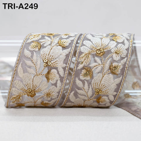 a decorative ribbon with a floral pattern in shades of gray and gold. The ribbon appears to be made of a shiny material and is displayed against a plain background.