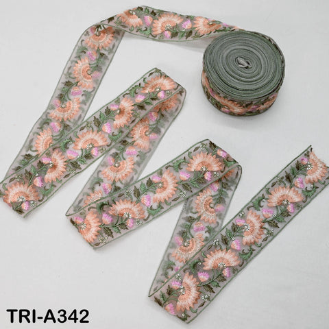 a collection of fabric ribbons with a floral pattern, including a large roll of green and orange floral fabric and several smaller pieces of the same fabric.