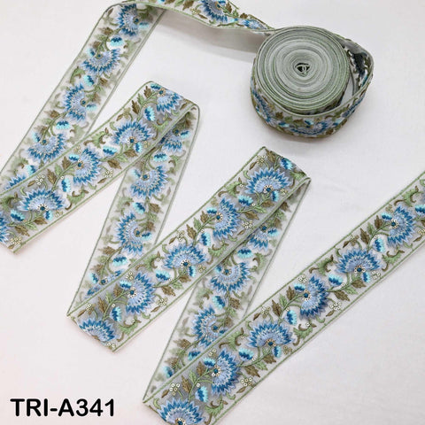 a collection of decorative fabric pieces, including a spool of embroidered fabric and several pieces of fabric with a floral pattern.
