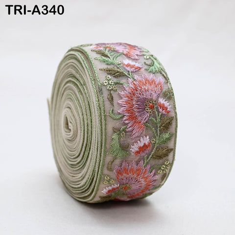 A close-up image of a decorative fabric with a floral pattern, featuring a combination of pink and green flowers and leaves.