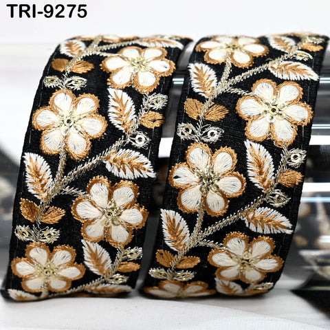 two ornate black and gold embroidered fabric pieces with intricate floral designs.