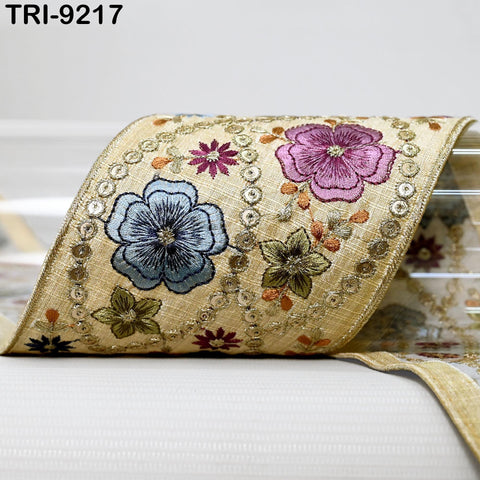 a decorative fabric with a floral pattern, including blue, purple, and green flowers, as well as small circular embellishments.