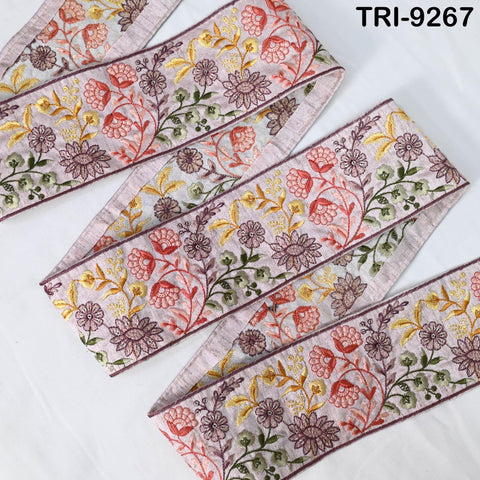 a decorative fabric with a floral pattern, featuring a variety of colorful flowers and leaves. The fabric appears to be a decorative trim or border, with a repeating floral design.