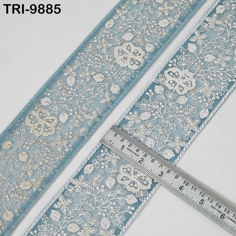 a close-up view of a decorative fabric with a floral pattern, featuring a ruler for scale.