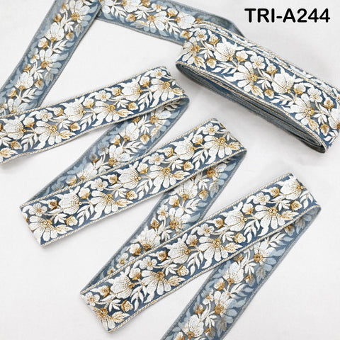 several spools of blue and white floral embroidery ribbon, arranged on a white background.