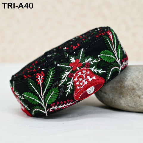 A close-up image of a decorative headband with a floral pattern in red, green, and white colors, resting on a white surface.
