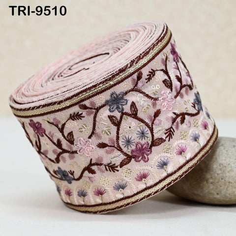 A close-up image of a decorative fabric with a floral pattern, featuring a pink and brown color scheme.