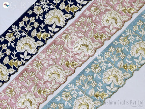 three pieces of fabric with intricate floral embroidery in various colors, including navy blue, pink, and light blue.