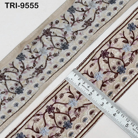 two pieces of fabric with intricate floral embroidery. A ruler is placed on top of the fabric, indicating the size of the fabric.