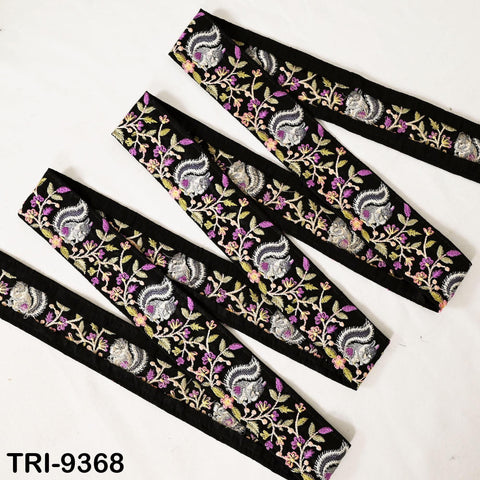 a collection of decorative fabric pieces with a floral pattern in shades of black, purple, and white. The fabric appears to be a type of ribbon or trim, with a repeating pattern of leaves and flowers. The image does not contain any text or other discernible objects.