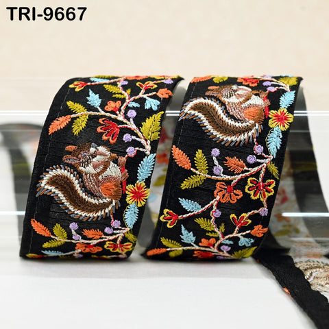 two black fabric pieces with colorful floral embroidery.