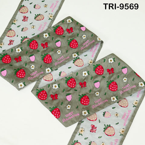 a collection of fabric items with a strawberry pattern, including a scarf, a blanket, and a pillow.