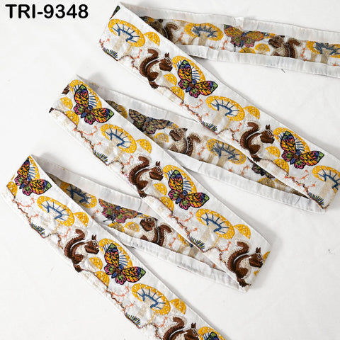 a collection of decorative fabric pieces with a repeating pattern of butterflies and squirrels on a white background.