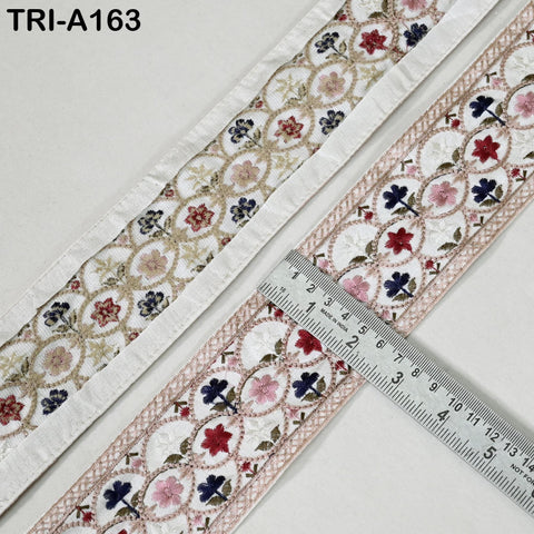 two pieces of fabric with a floral pattern, and a ruler is placed between them to measure the width of the fabric.