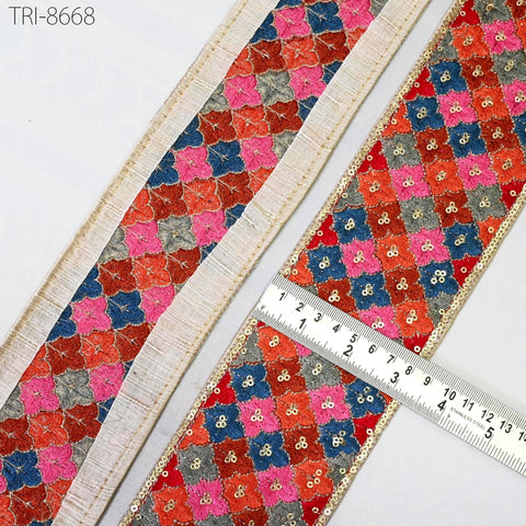 two pieces of fabric with a colorful, intricate floral pattern. One piece is placed on the left side of the image, and the other is on the right side. A ruler is placed in the center of the image, indicating the size of the fabric pieces.