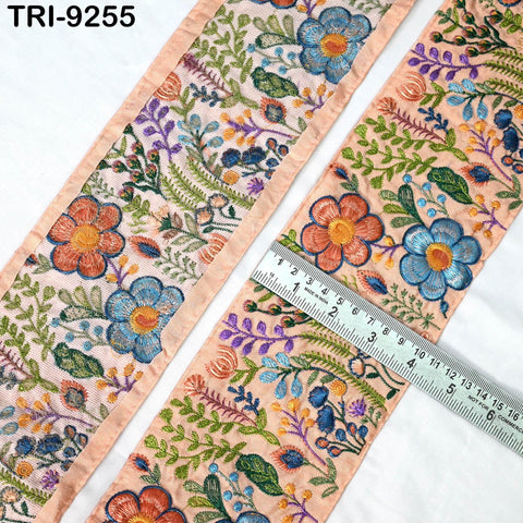 a close-up view of a decorative fabric with a floral pattern, featuring a ruler for scale.