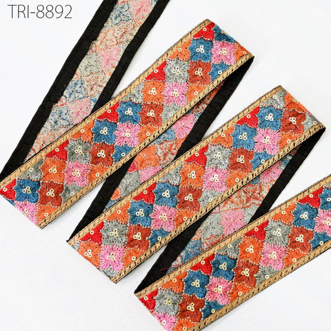 a collection of colorful, patterned fabric pieces with a floral design. The fabric appears to be made of a material with a metallic or sequined texture, and the patterns are intricate and visually appealing.