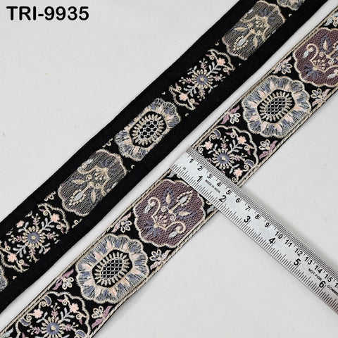 a decorative black and white fabric with a floral pattern, and a ruler is placed on top of it, indicating the size of the fabric.