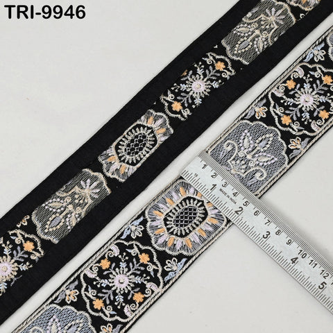 a close-up view of a decorative black and white fabric with intricate floral patterns. A ruler is placed next to the fabric, indicating its size.