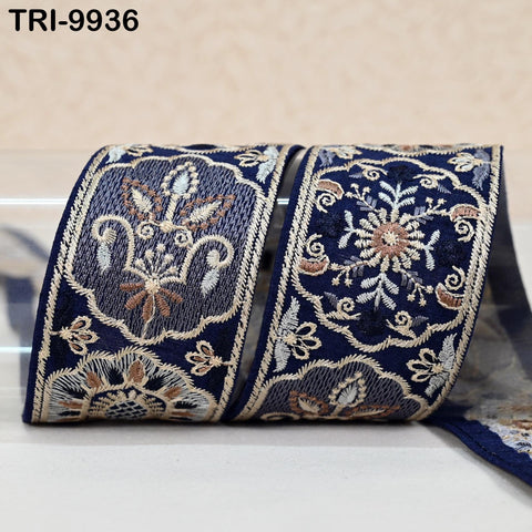 two rolls of decorative fabric with intricate embroidered patterns in shades of blue and white.