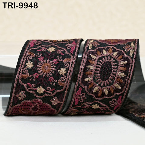 two decorative fabric pieces with intricate floral patterns in shades of black, pink, and gold. The pieces appear to be made of a shiny material, possibly silk or satin, and are displayed on a white surface.