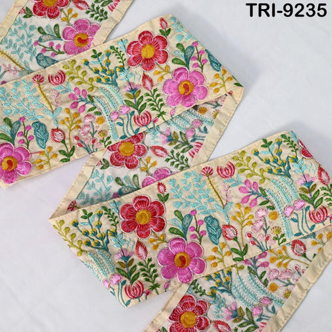 a close-up view of a decorative fabric with a floral pattern. The fabric features a variety of colorful flowers and leaves, including pink, red, and green flowers, as well as green leaves. The fabric appears to be a beige color, and the pattern is intricate and detailed.